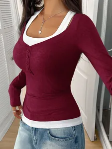 Close-up of burgundy long-sleeve top with white mock-layered collar and button details