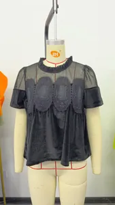 Détail d'un haut noir à manches courtes avec broderie en résille et col rond sur mannequin
