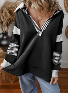 Detail of loose black sweatshirt with white striped deep V-neck and sleeve panels