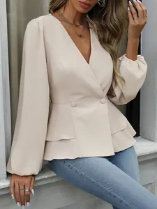 Detail einer beigen Schößchenbluse mit V-Ausschnitt, Laternenärmeln und Taillenknöpfen.
