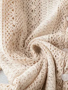 Gros plan sur la dentelle évidée crème et les boutons blancs d'une chemise élégante
