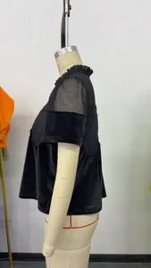 Détail latéral d'un haut noir à manches courtes avec broderie en résille et dentelle