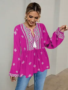Detailed view of ethnic fuchsia blouse with white embroidery and lantern sleeves