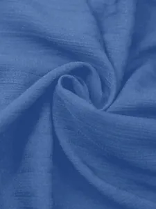 Macrodetail van blauwe kreukelstoftextuur voor etnische damesblouse met fladderende mouwen