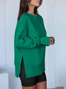Détail du sweat-shirt vert surdimensionné avec fente latérale pour un look décontracté.
