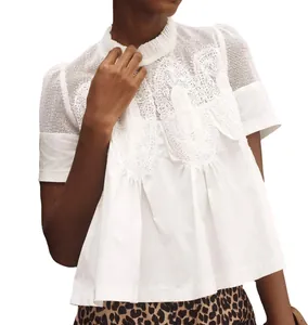 Gros plan d'un haut blanc à manches courtes avec broderie en dentelle et mesh fin