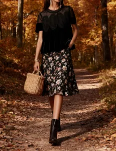 Elegant black velvet top with mesh embroidery shown in a scenic autumn forest setting