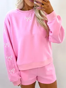 Vista dettagliata del set felpa rosa girocollo e pantaloncini con ricamo a fiocco