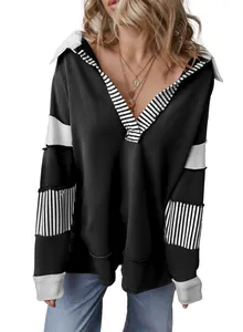 Detailed view of women's loose black sweatshirt with deep V-neck and striped patchwork