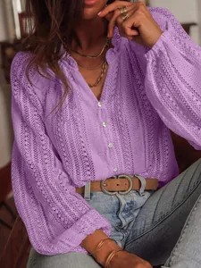 Détail d'une chemise en dentelle creuse violette avec col en V et boutonnage à l'avant