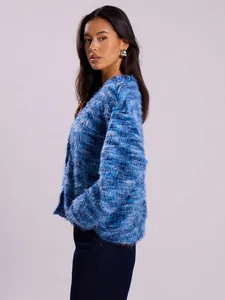 Side view detail of a blue fuzzy textured cardigan with long sleeves and soft hairy finish