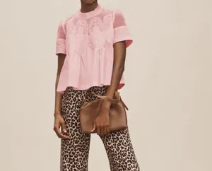 Vue détaillée d'une blouse rose avec broderie en dentelle fine et détails en résille