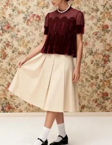 Detailed view of burgundy velvet blouse with elegant mesh embroidery and lace trim.