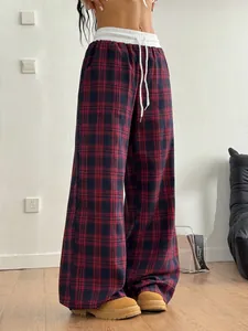 Gros plan sur un pantalon large à carreaux rouge et noir avec cordon blanc
