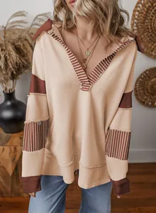 Detail shot of a casual oversized V-neck sweatshirt featuring striped patchwork