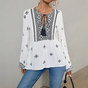 Vintage ethnic style white blouse featuring embroidery, tassel tie and lantern sleeves.