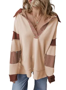 Close-up of the striped patchwork design and deep V-neck on an oversized beige sweatshirt