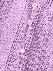 Vue macro détaillée du tissu en dentelle au crochet ajouré violet et des boutons blancs