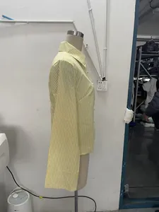 Side profile of a fashion yellow and white striped long-sleeve shirt on a mannequin