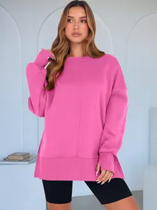 Vue détaillée d'un sweat-shirt rose fuchsia oversize à col rond avec fente latérale.