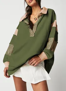 Close-up of a loose green and beige striped patchwork sweatshirt featuring a deep V-neckline