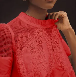Gros plan sur les détails élégants de la broderie en dentelle rouge et du tissu en maille.