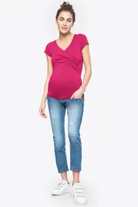 Vista intera di una donna incinta con top per allattamento incrociato magenta e jeans