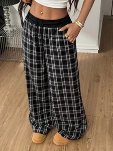 Gros plan d'un pantalon à carreaux ample avec cordon de serrage et taille haute droite.