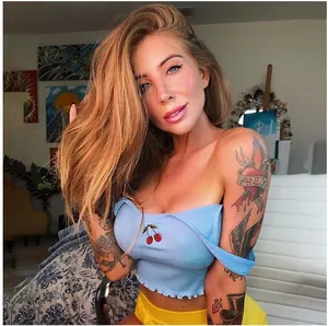 Detailed shot of a stylish blue ribbed crop top featuring cute red cherry embroidery