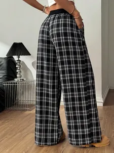 Pantalon écossais noir et blanc à taille haute et jambe large pour un look décontracté.