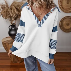 Casual white V-neck pullover with blue striped color block details and loose fit.
