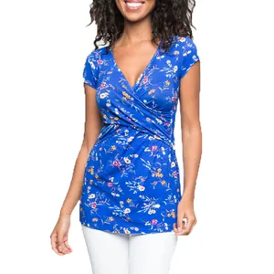 Dettaglio della maglia premaman blu a fiori con scollo a V e design a incrocio.