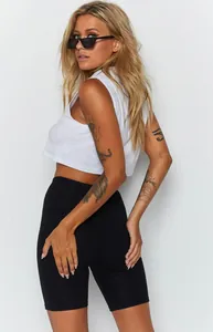 Side view of woman wearing white crop top and black high-waisted yoga biker shorts