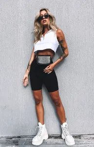 Model wearing high-waisted black yoga biker shorts and white crop top in streetwear style