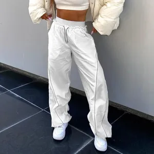 Detail view of stylish white high-waisted drawstring trousers with loose fit design
