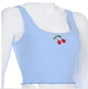 Close-up detail of light blue ribbed knit crop top with red cherry embroidery for women