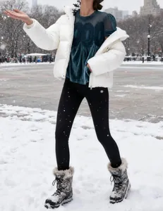 Detail shot of an elegant dark teal velvet top with mesh lace embroidery in a snowy park.