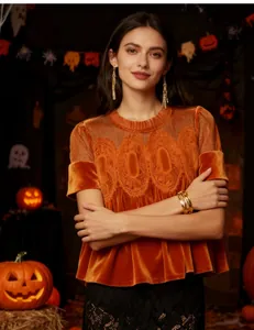 Detail of orange velvet top featuring mesh lace embroidery and elegant round neckline