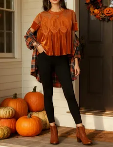 Detailed look at the orange velvet top featuring intricate lace embroidery and mesh fabric.