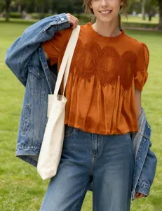 Detailed view of orange velvet blouse with delicate lace embroidery and mesh detailing.