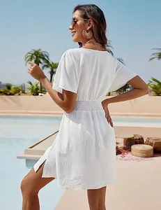 Back view of a white V-neck beach dress featuring an elastic waist and side slits.