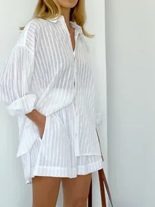 Detailed shot of white striped shirt and shorts set featuring jacquard texture and puff sleeves