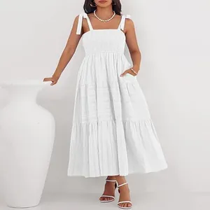 Robe longue blanche élégante à bretelles, bustier smocké et jupe plissée à volants