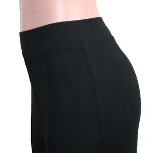 Close-up detail of high-waisted black flared trousers showing fabric texture and slim fit design