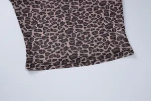 Close-up detail of sheer leopard print mesh fabric showing neat hem stitching quality