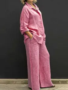 Vista laterale di una donna con un set camicia in lino rosa e pantaloni a gamba larga