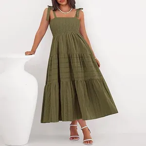Détail d'une robe midi à volants vert olive avec buste smocké et bretelles nouées.
