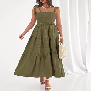 Détail de la robe longue vert olive avec corsage smocké, jupe à volants et bretelles nouées