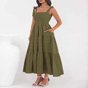 Détail d'une robe longue vert olive à bustier smocké et bretelles nouées.