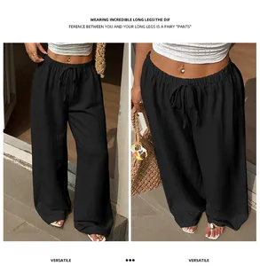 Detail view of women's black wide-leg trousers with textured fabric and elastic waist